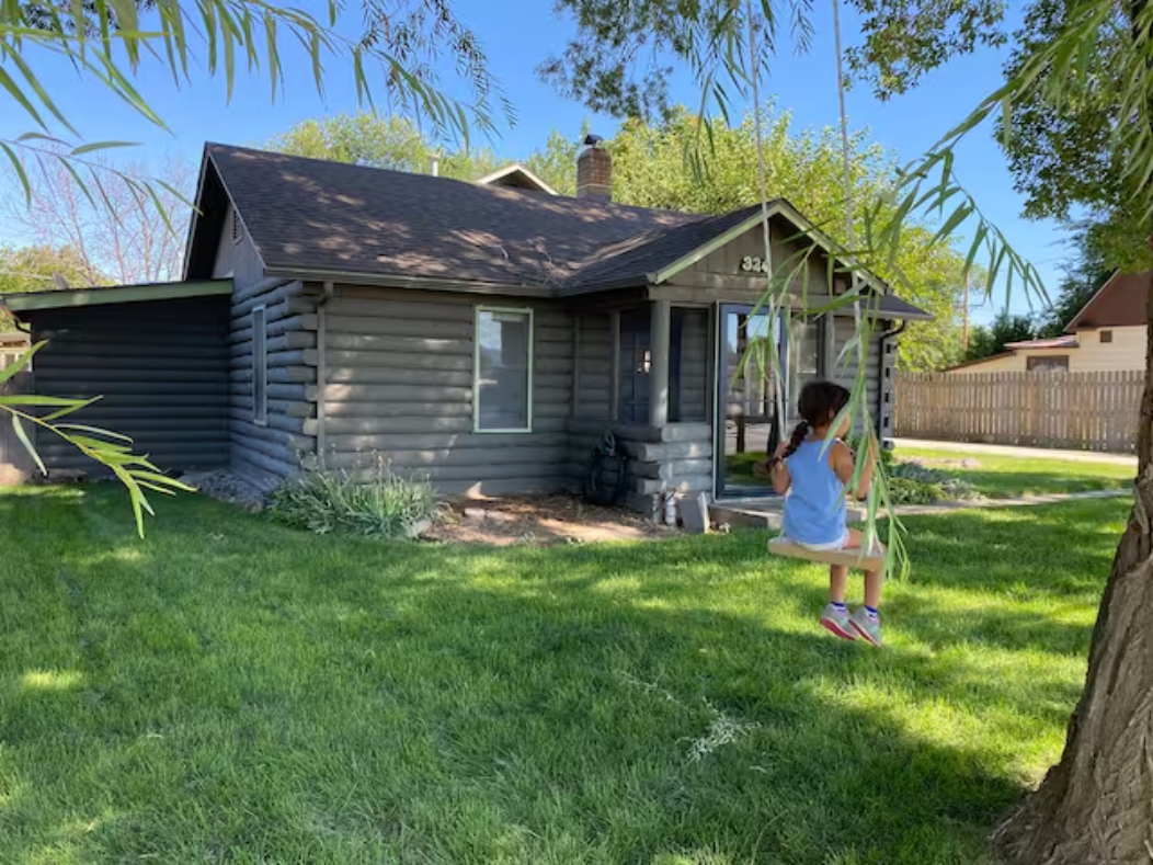 Cabin exterior with yard and tree swing