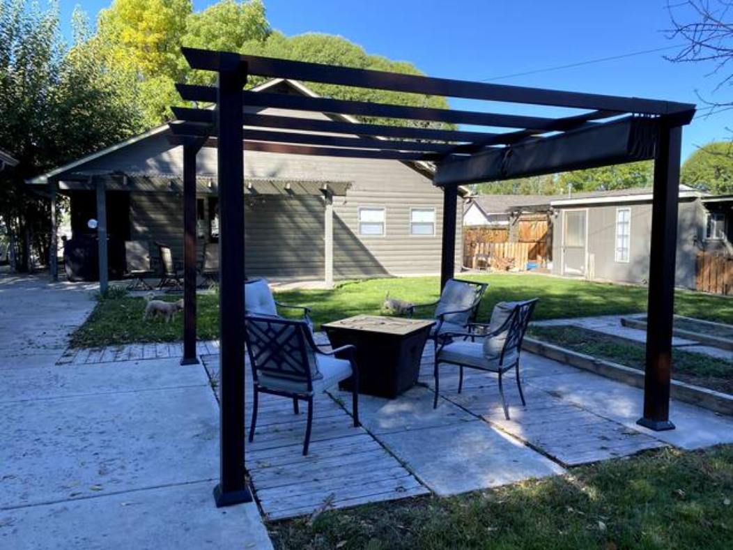 Nighttime pergola with fire pit and string lights
